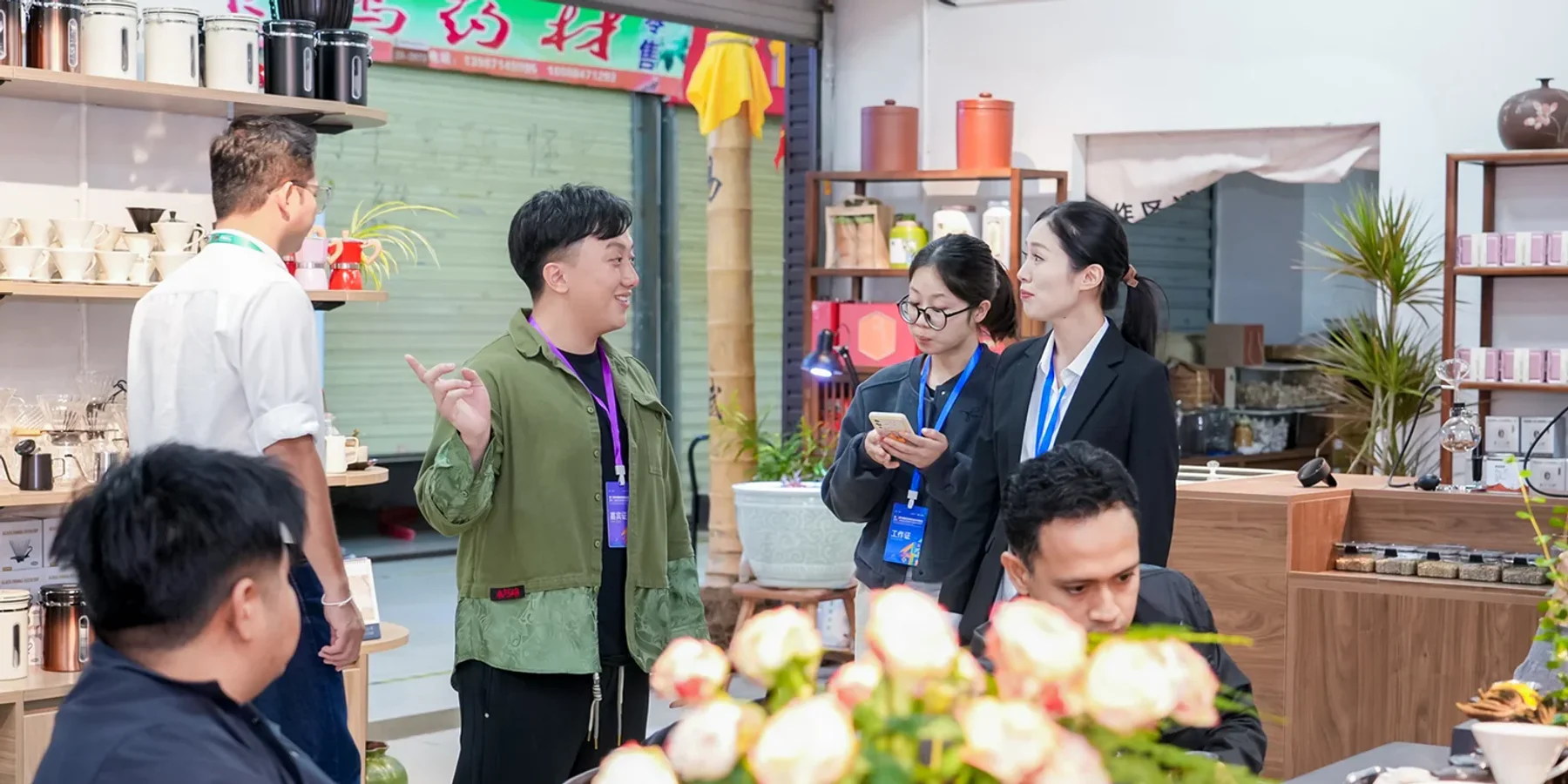 Ryu Gege สนทนาและประสานงานกับผู้ร่วมงานชาวไทยและจีนในพื้นที่แสดงสินค้า